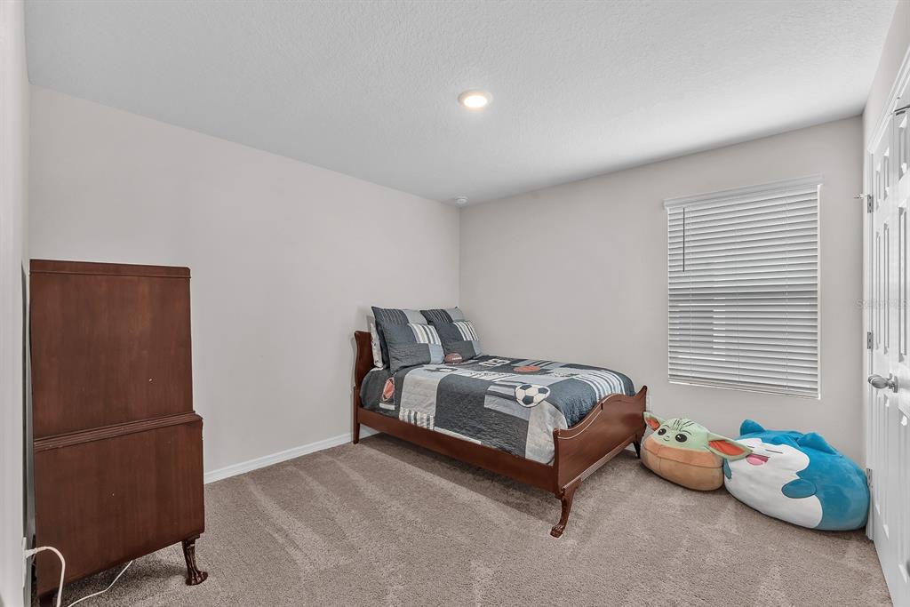 12952 Wellspring Drive Lithia, FL 33547 - Photo 26 of 46 a spacious bedroom with a bed and a window