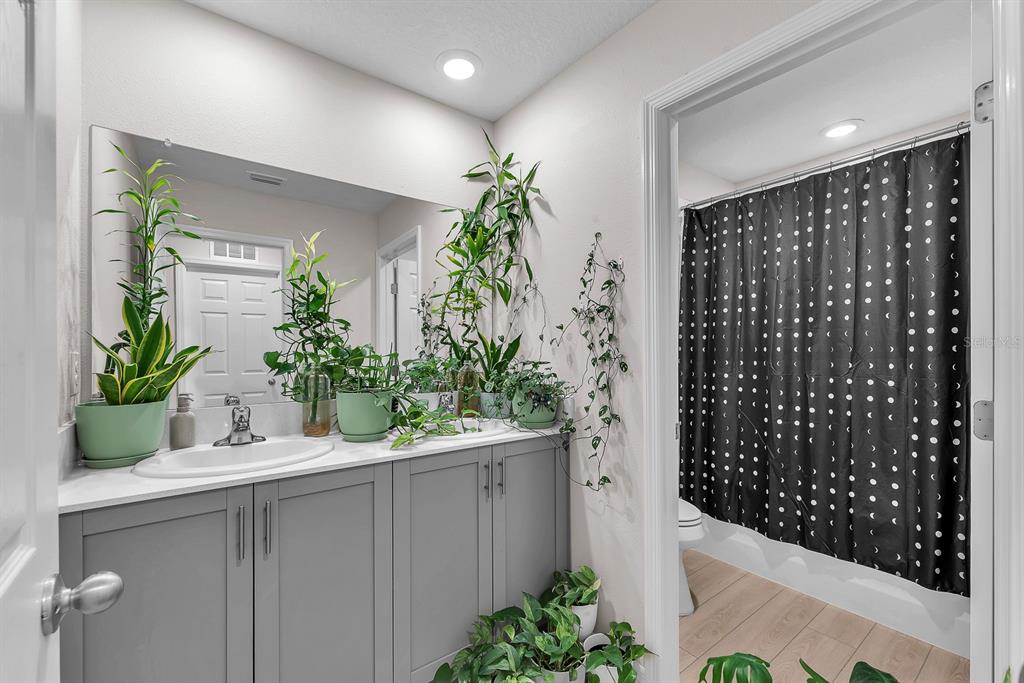 12952 Wellspring Drive Lithia, FL 33547 - Photo 30 of 46 a bathroom with a shower curtain and a potted plant