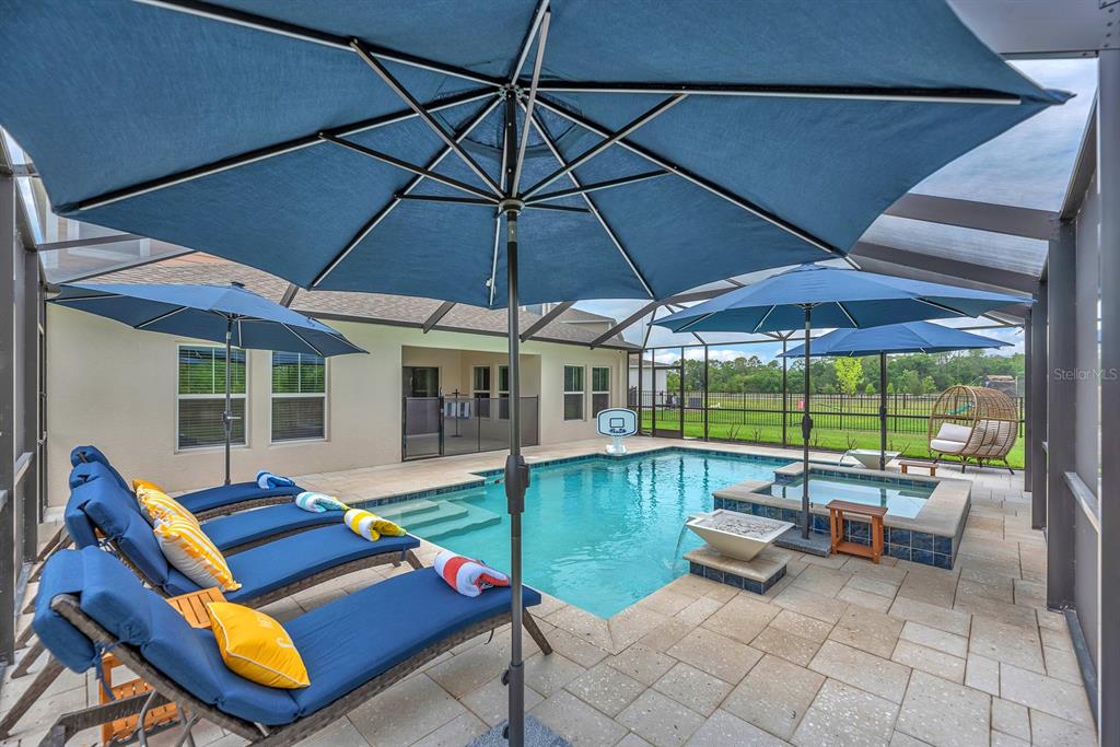 12952 Wellspring Drive Lithia, FL 33547 - Photo 35 of 46 a patio with lawn chairs under an umbrella