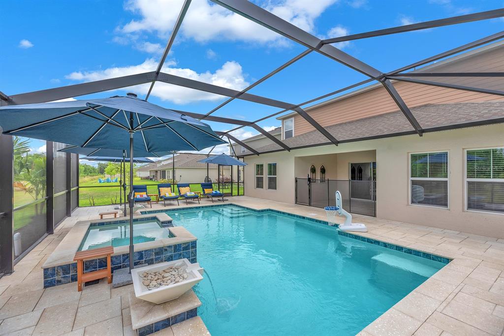 12952 Wellspring Drive Lithia, FL 33547 - Photo 36 of 46 a view of a backyard with table and chairs under an umbrella