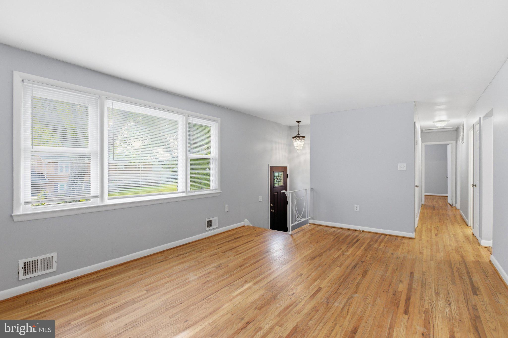 12908 Glynis Road Clinton, MD 20735 - Photo 3 of 32 a view of an empty room with wooden floor and a window
