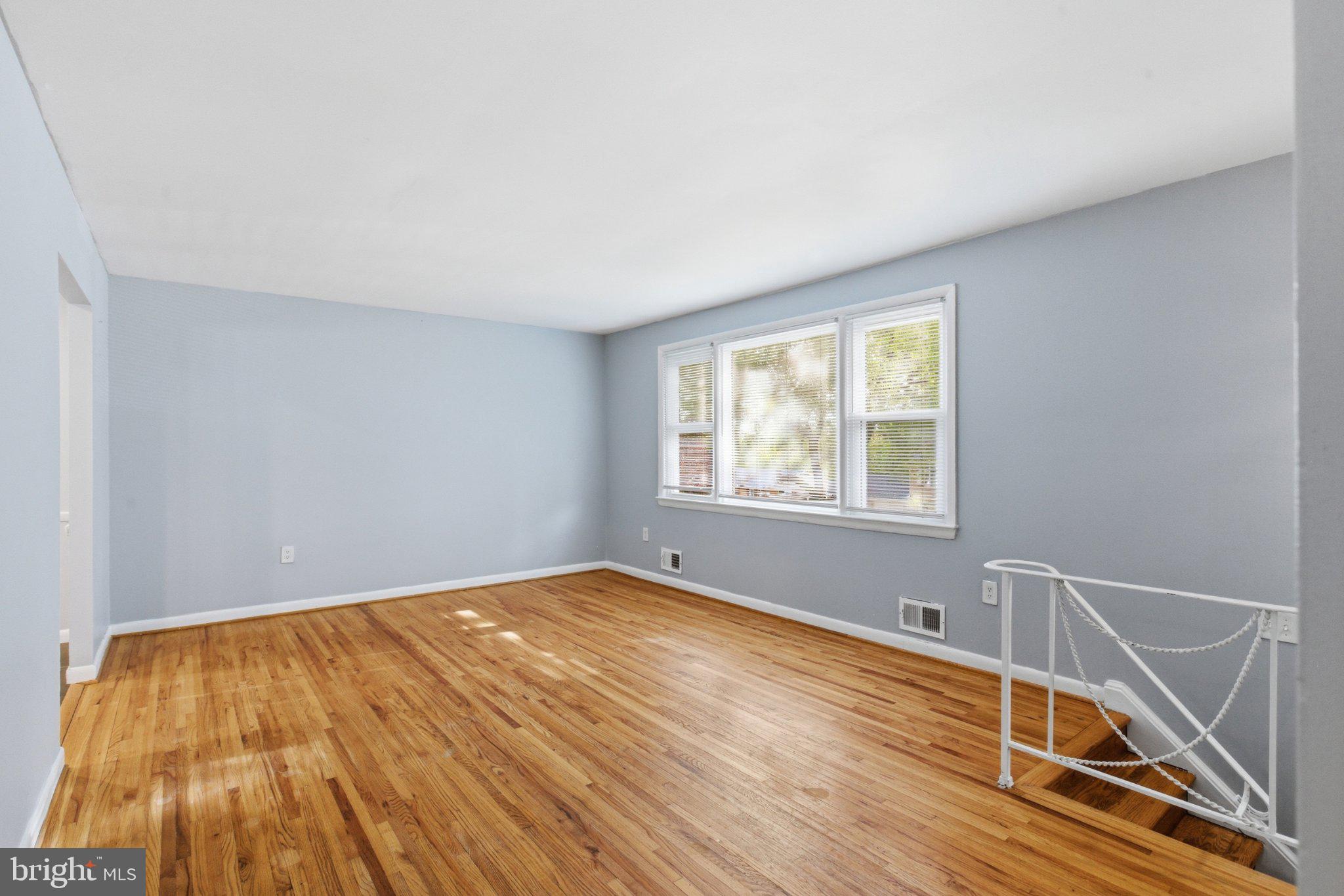 12908 Glynis Road Clinton, MD 20735 - Photo 4 of 32 a view of an empty room with wooden floor and a window