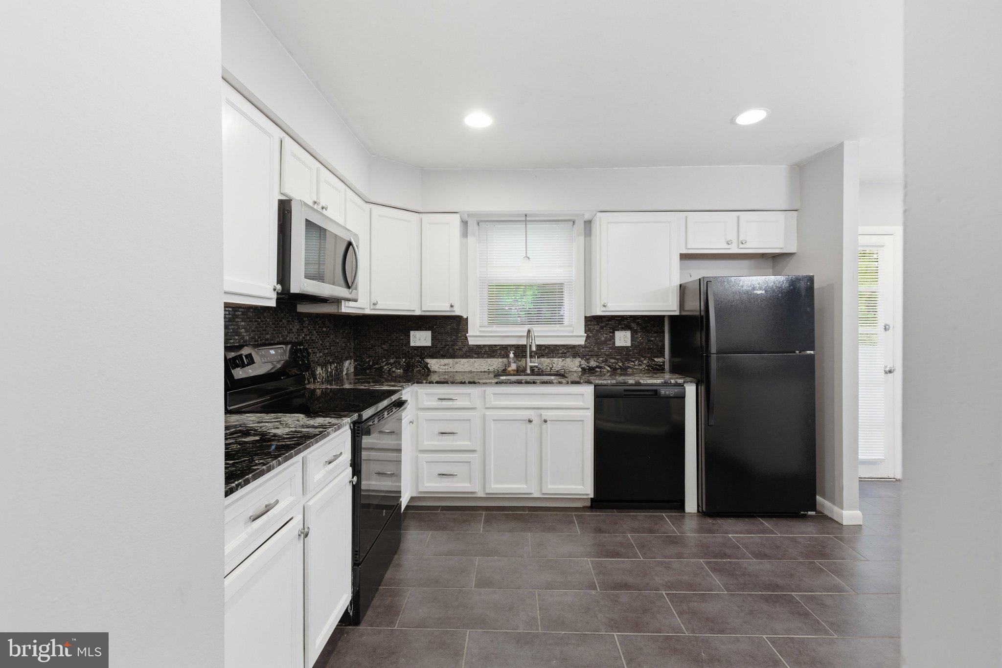 12908 Glynis Road Clinton, MD 20735 - Photo 8 of 32 a kitchen with a refrigerator and a stove top oven