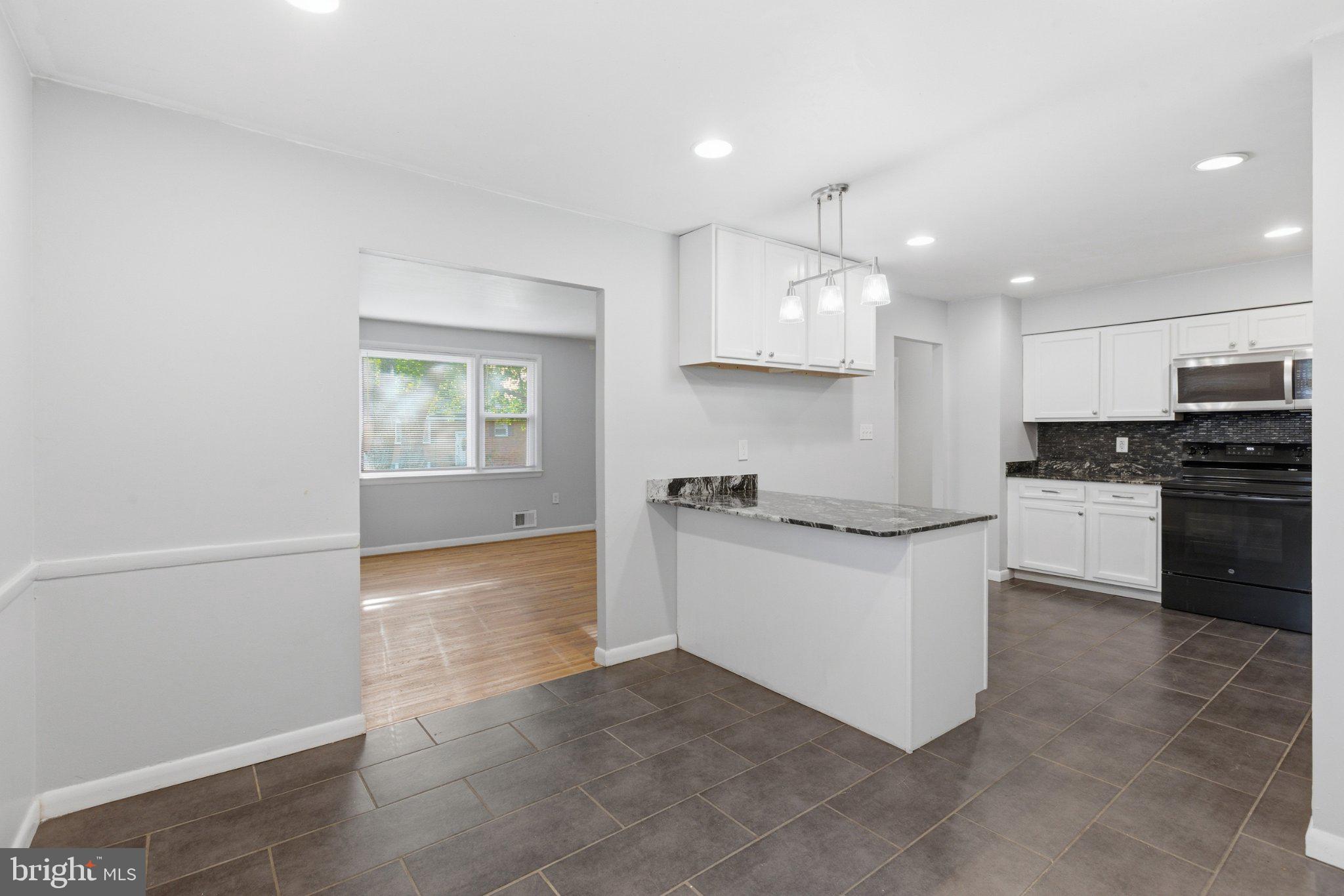 12908 Glynis Road Clinton, MD 20735 - Photo 10 of 32 a kitchen with granite countertop white cabinets and white appliances