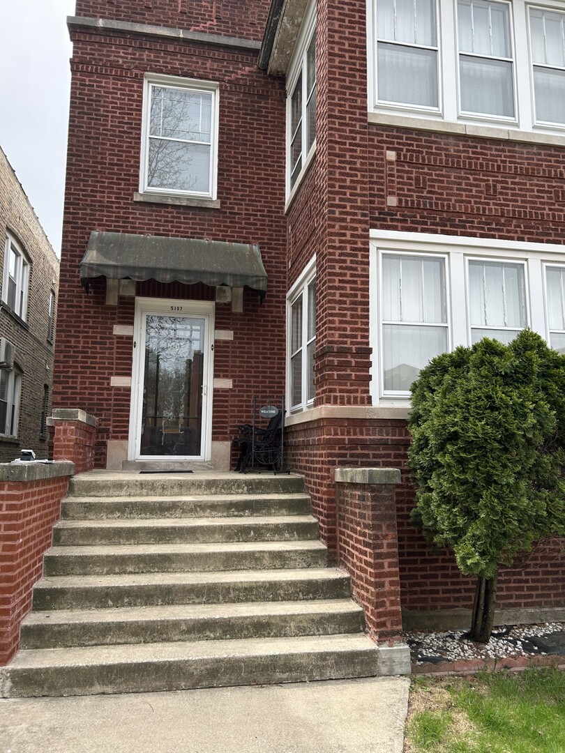 5107 West Cullom Avenue, Unit 2 Chicago, IL 60641 - Photo 1 of 22 a front view of a house with a garden
