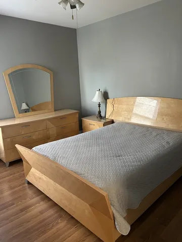a bed sitting in a bedroom with wooden floor
