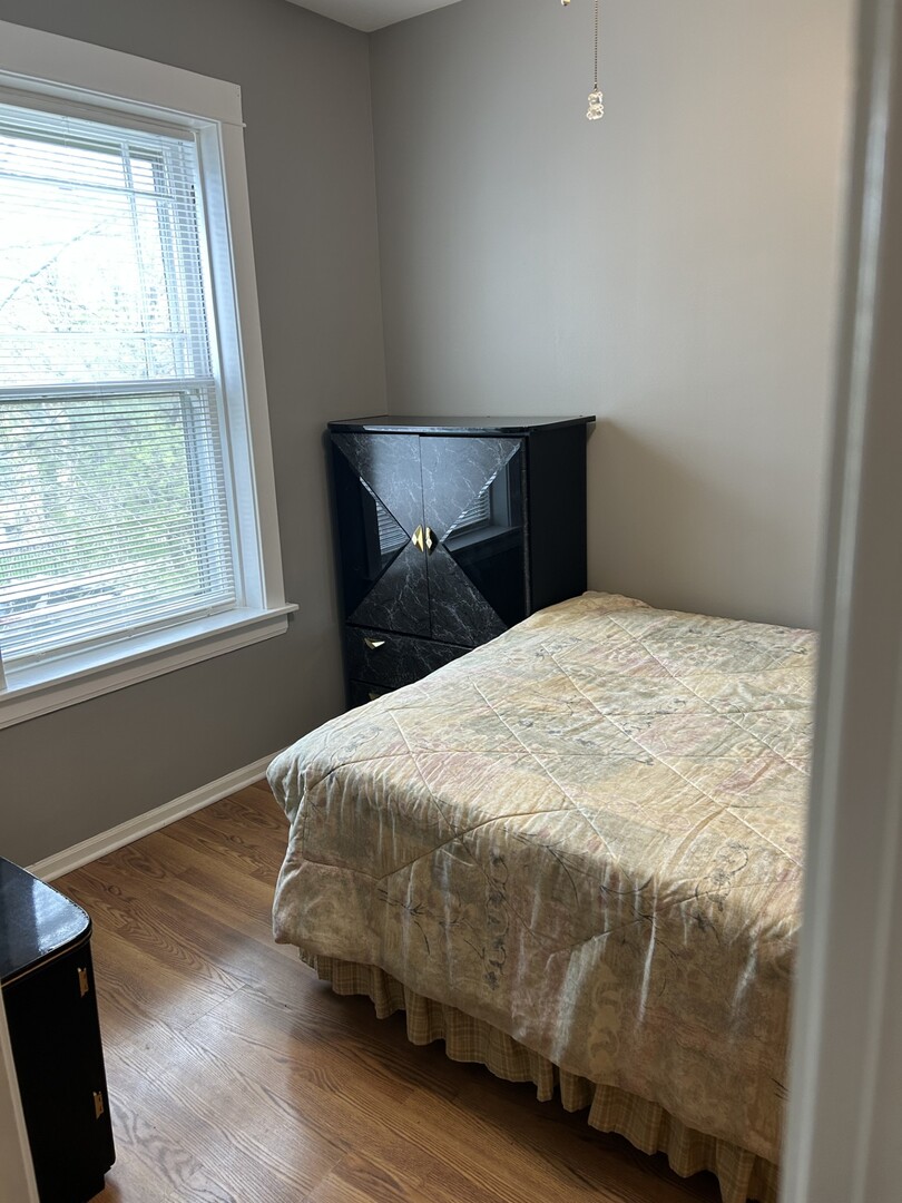 5107 West Cullom Avenue, Unit 2 Chicago, IL 60641 - Photo 12 of 22 a bed sitting in a bedroom next to a window