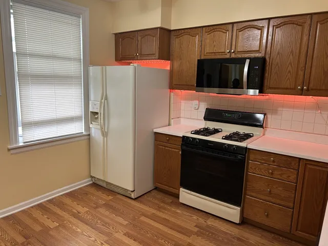 a kitchen with stainless steel appliances granite countertop a refrigerator and a stove top oven