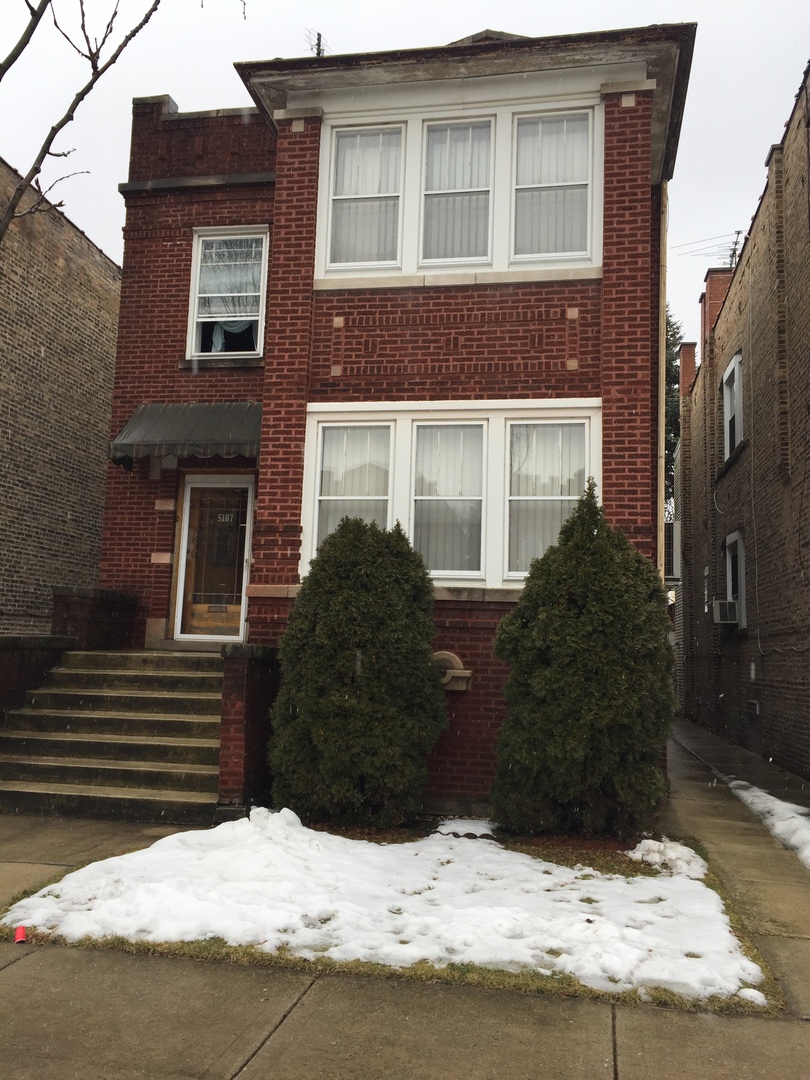 5107 West Cullom Avenue, Unit 2 Chicago, IL 60641 - Photo 21 of 22 a view of a house with a yard covered in snow