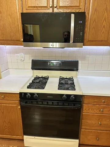 a stove top oven sitting inside of a kitchen