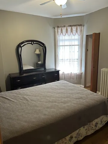 a bedroom with a bed window and mirror