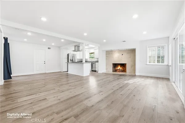 a view of kitchen with refrigerator stove and white cabinets