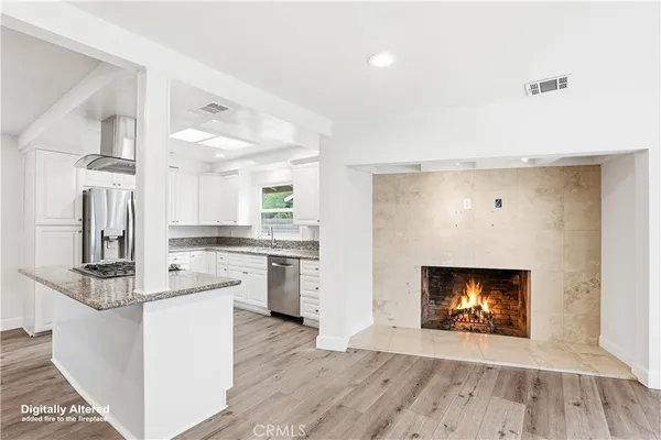 a kitchen with granite countertop stainless steel appliances a stove cabinets and wooden floor