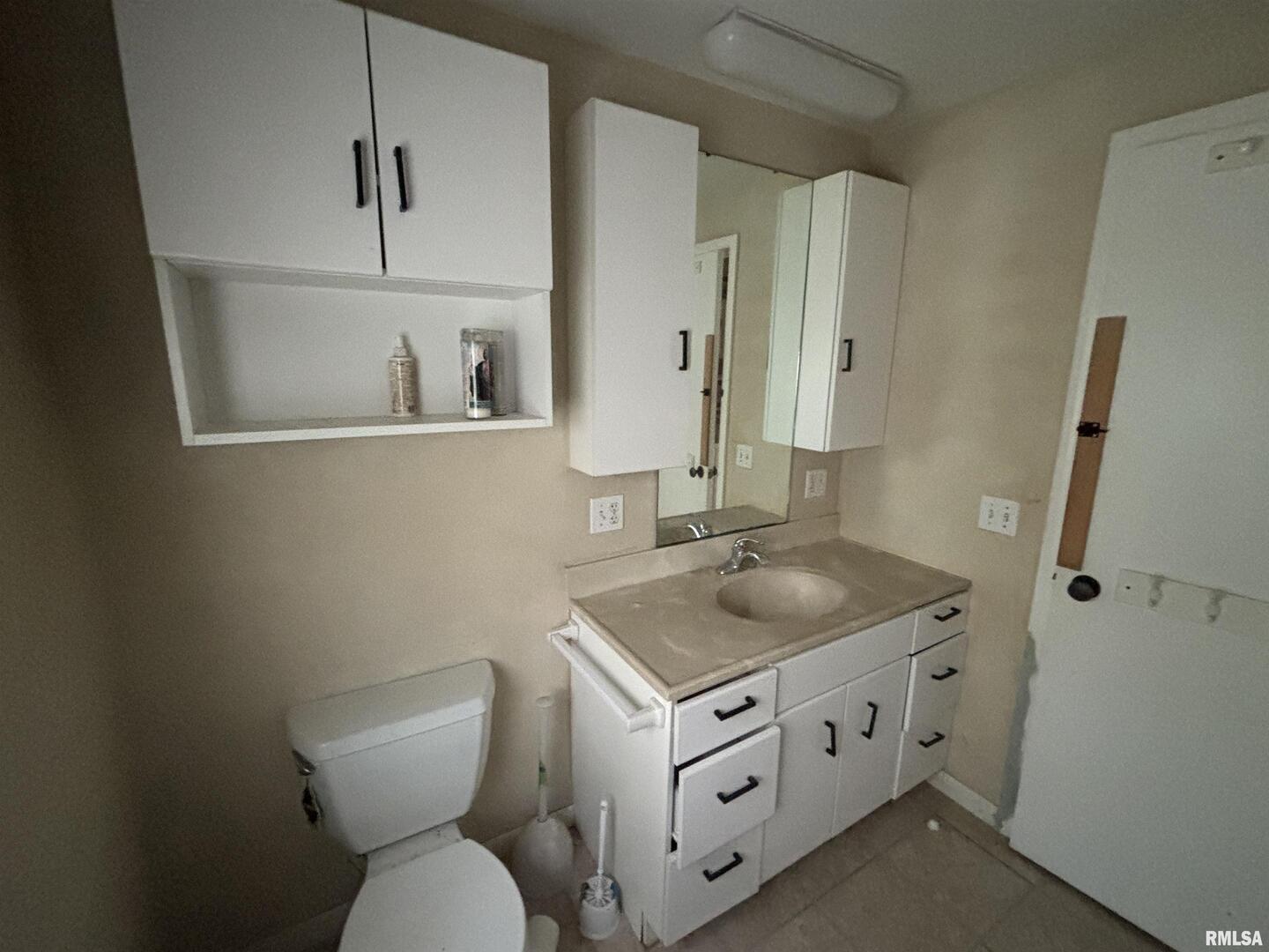 560 South 4th Street Clinton, IA 52732 - Photo 12 of 14 a bathroom with a toilet sink and mirror