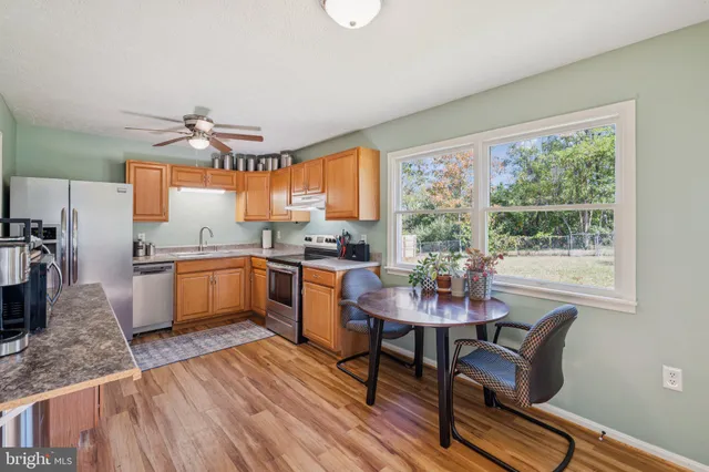 a kitchen with a table chairs a sink dishwasher window and cabinets