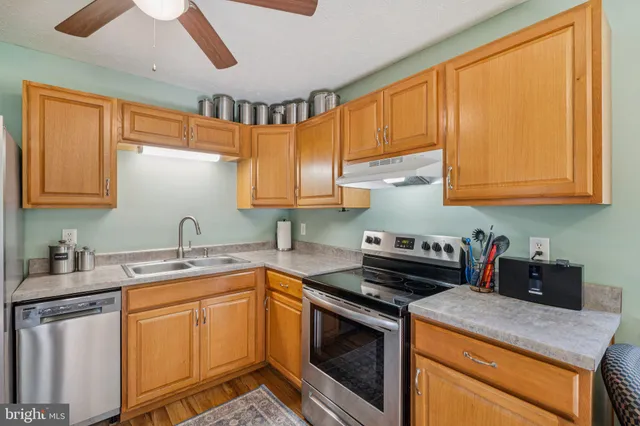 a kitchen with stainless steel appliances granite countertop a sink stove and cabinets