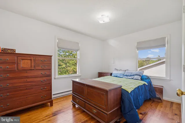 a bedroom with a bed and a dresser next to a window