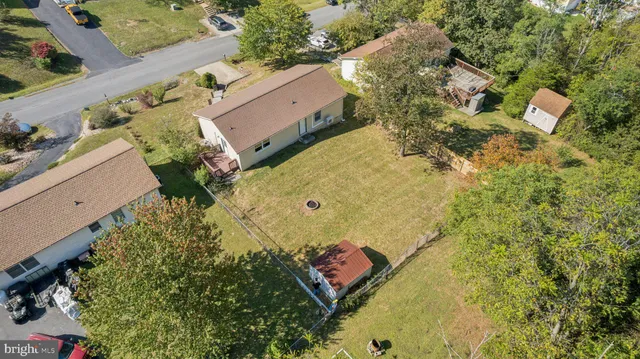an aerial view of a house with a yard and trees