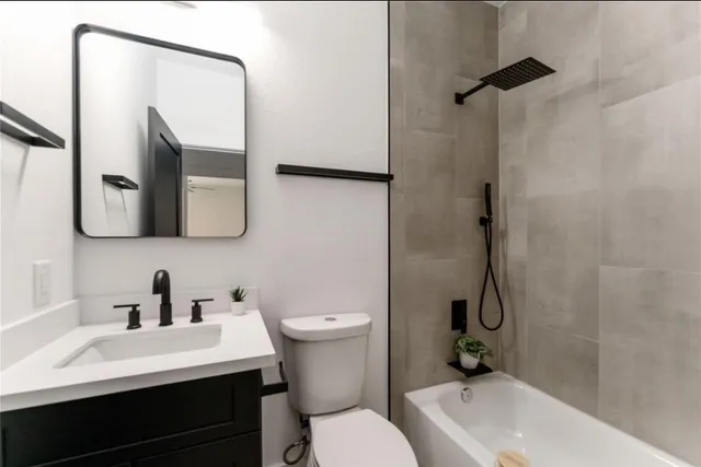 a bathroom with a sink vanity mirror and toilet