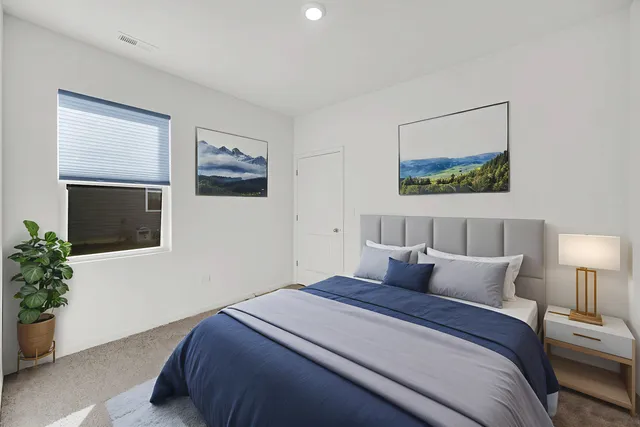 a bedroom with bed painting on the wall and a potted plant
