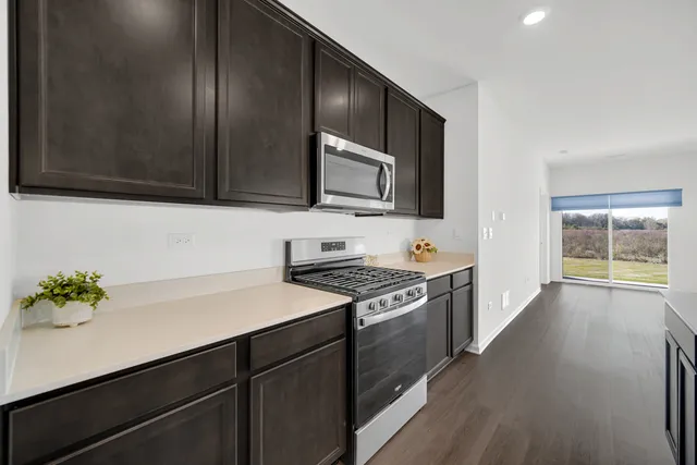 a kitchen with stainless steel appliances a stove microwave and sink