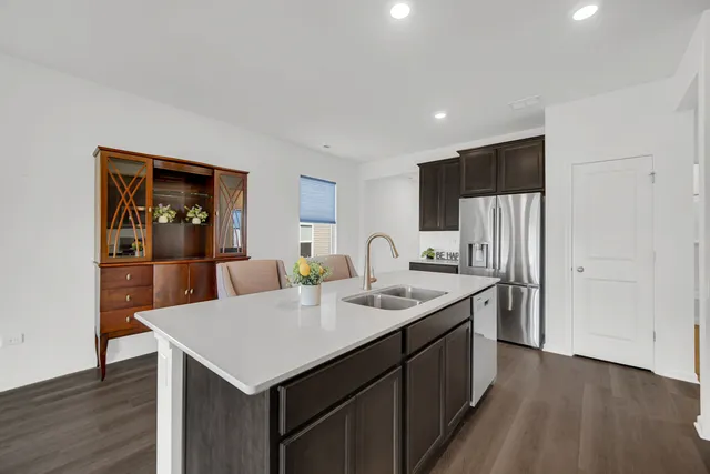 a kitchen with a sink a refrigerator and wooden floor