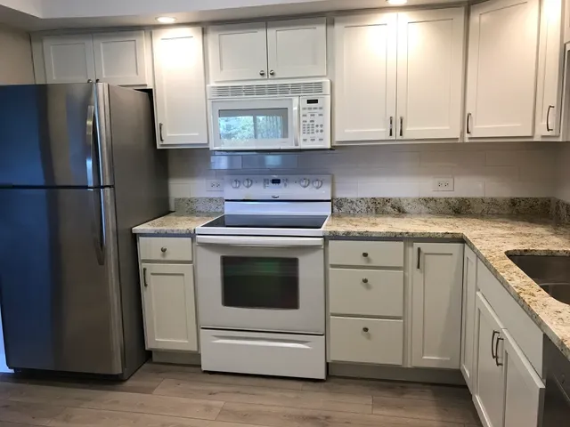a kitchen with appliances a sink and cabinets