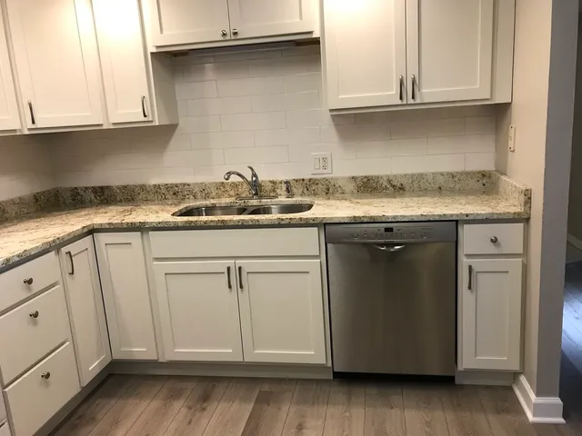a kitchen with granite countertop cabinets and white appliances