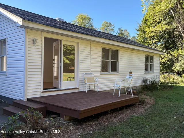 a view of a wooden chairs and table in the backyard