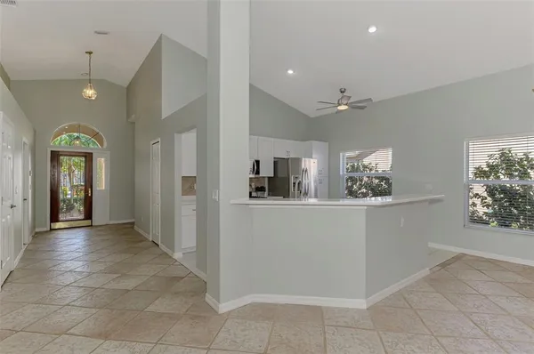 a view of a hallway to a livingroom with furniture and windows