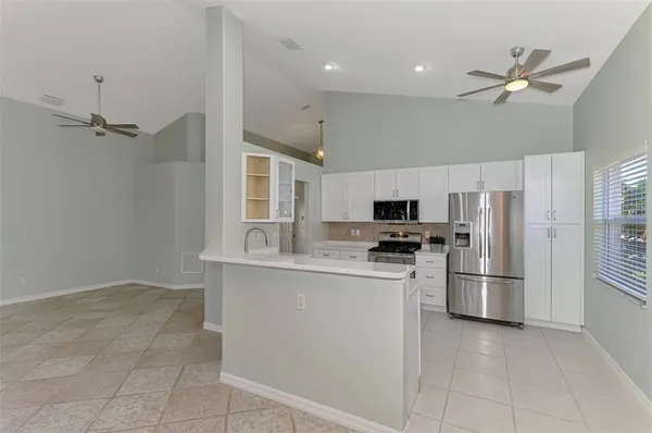 a kitchen with stainless steel appliances white cabinets and a stove top oven