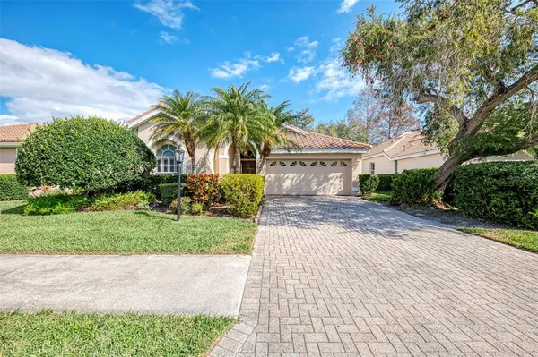 a palm tree sitting in front of a house with a yard