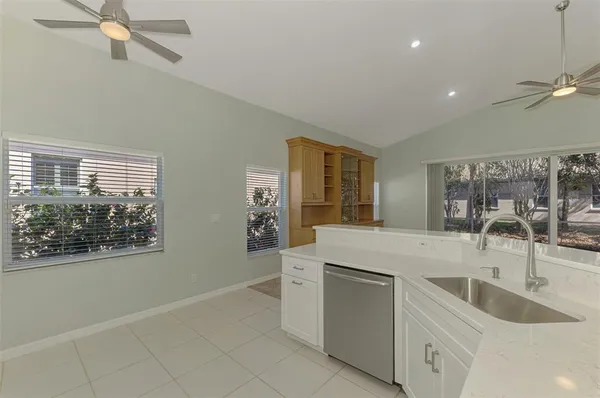 a kitchen with white cabinets and sink