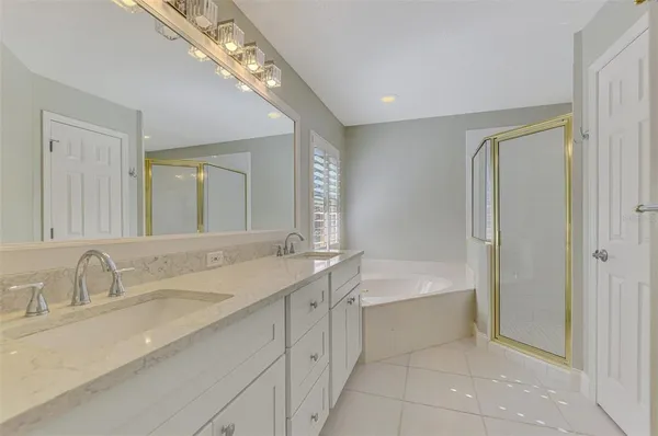 a bathroom with a tub shower and a sink