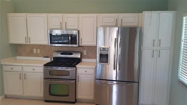 a kitchen with cabinets and stainless steel appliances