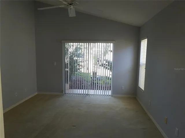 an empty room with a ceiling fan and window