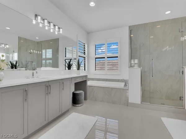 a bathroom with a tub sink and mirror