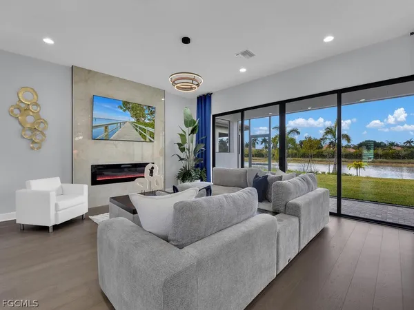 a living room with fireplace furniture and a large window