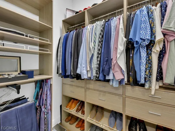 a view of walk in closet with clothes and shoes