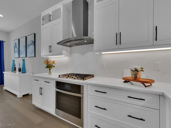 a kitchen with white cabinets and appliances