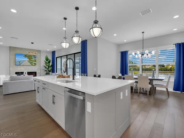 a large kitchen with lots of counter space a sink appliances and living room view