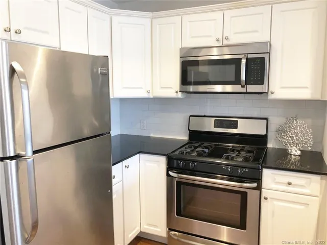 a kitchen with stainless steel appliances a refrigerator stove and microwave