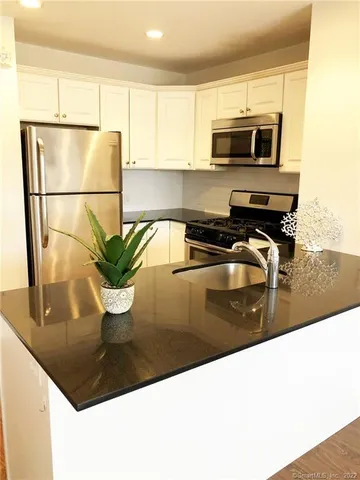 a kitchen with a sink a microwave and cabinets