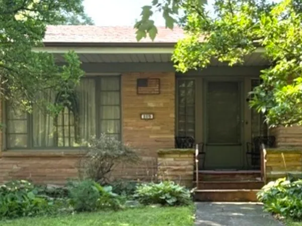 a front view of a house with a garden