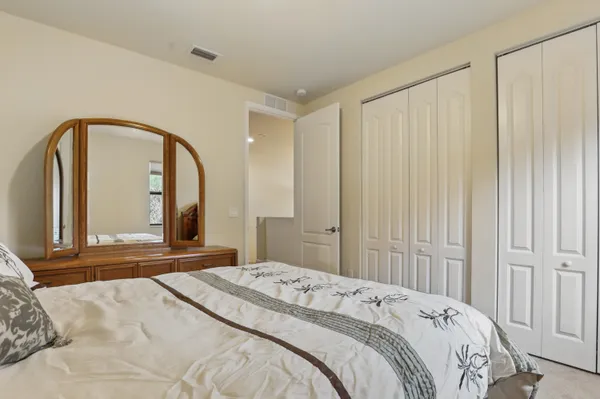 a bedroom with a large bed and a large mirror on dresser