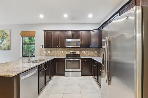 a kitchen with stainless steel appliances granite countertop a sink stove and refrigerator