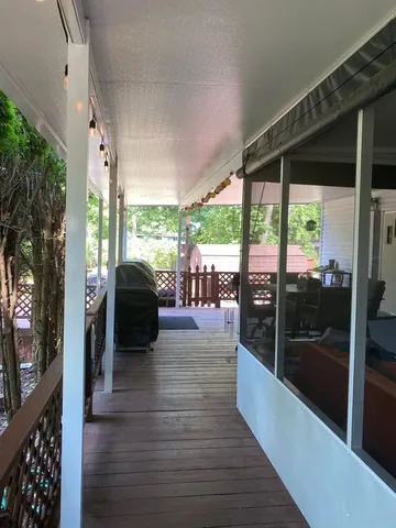 a living room with furniture large windows and wooden floor