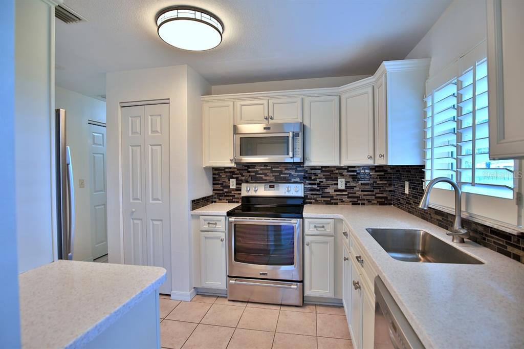12219 Southwest 26th Street Ocala, FL 34481 - Photo 11 of 63 a kitchen with a stove sink and microwave