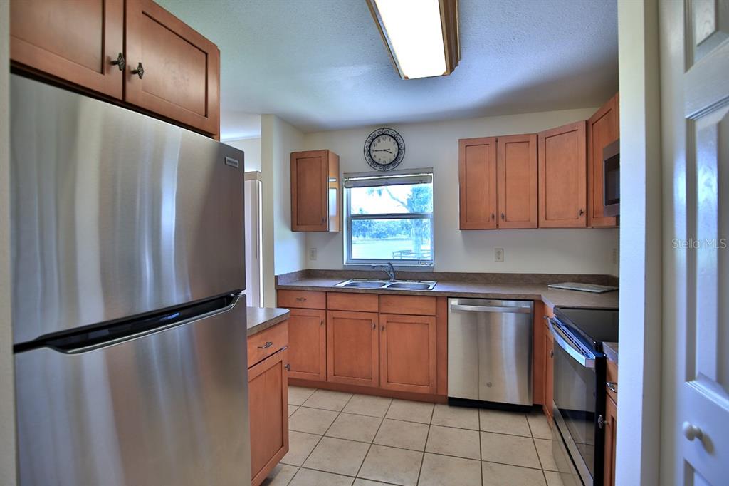 12219 Southwest 26th Street Ocala, FL 34481 - Photo 19 of 63 a kitchen with stainless steel appliances granite countertop a refrigerator a sink and a stove