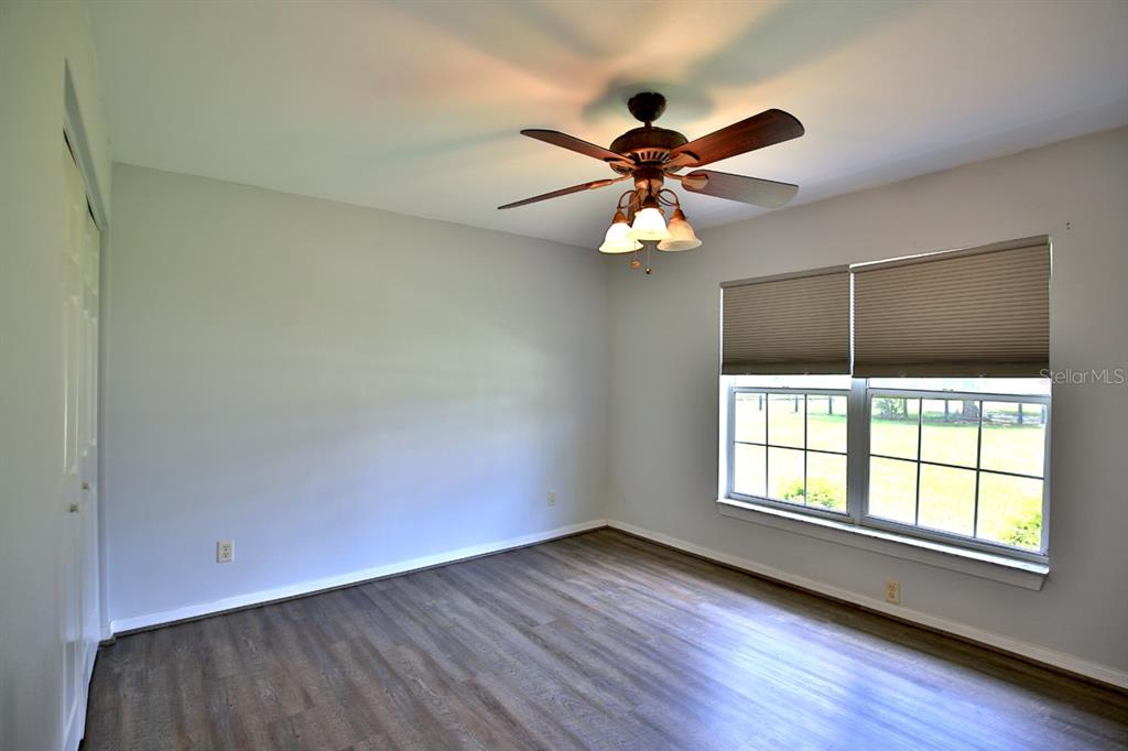 12219 Southwest 26th Street Ocala, FL 34481 - Photo 28 of 63 an empty room with wooden floor fan and windows